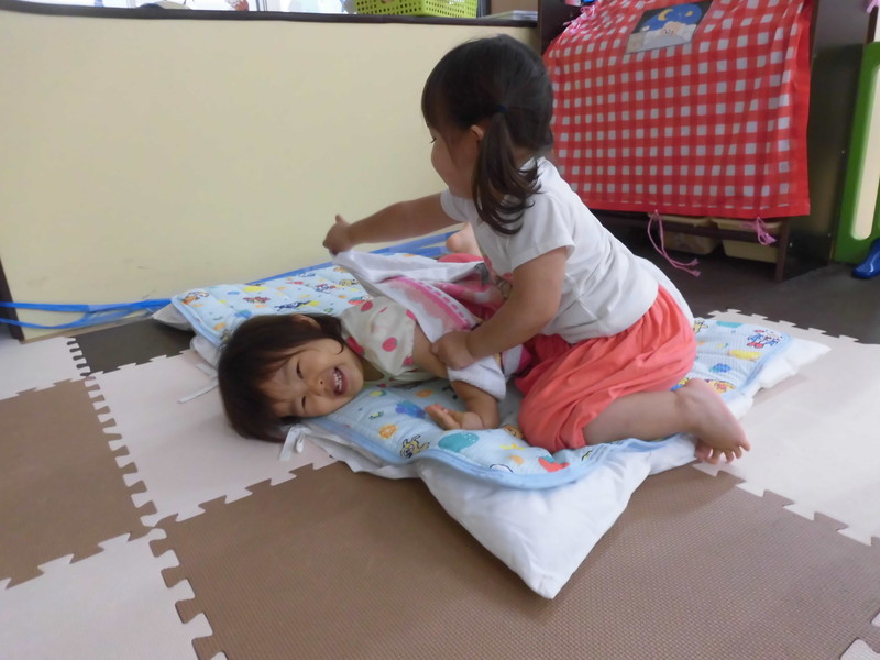 お布団掛けてあげるね。先生の真似っこが上手です。